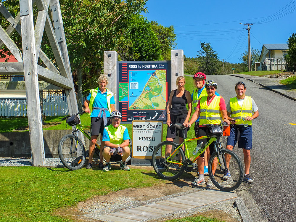 Cycle group beside roadside information sign