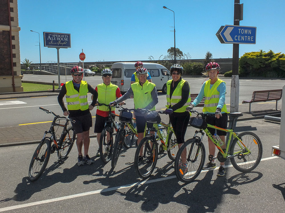 Cycle tour group standing on road side at the start of ride in Greymouth
