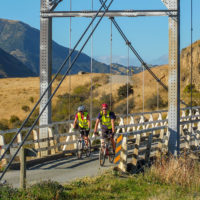 Cyclists riding across old Truss Bridge in River Valley