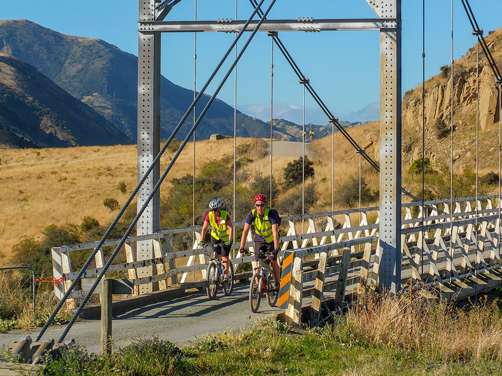 Cyclists riding across old Truss Bridge in River Valley